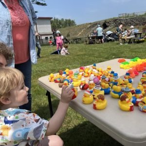 Child selecting rubber duck from display table